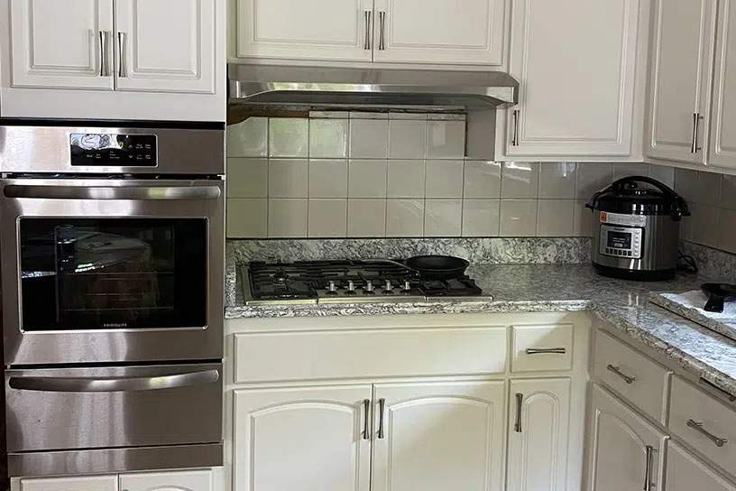 after cabinet resurfacing in white with white tile backsplash